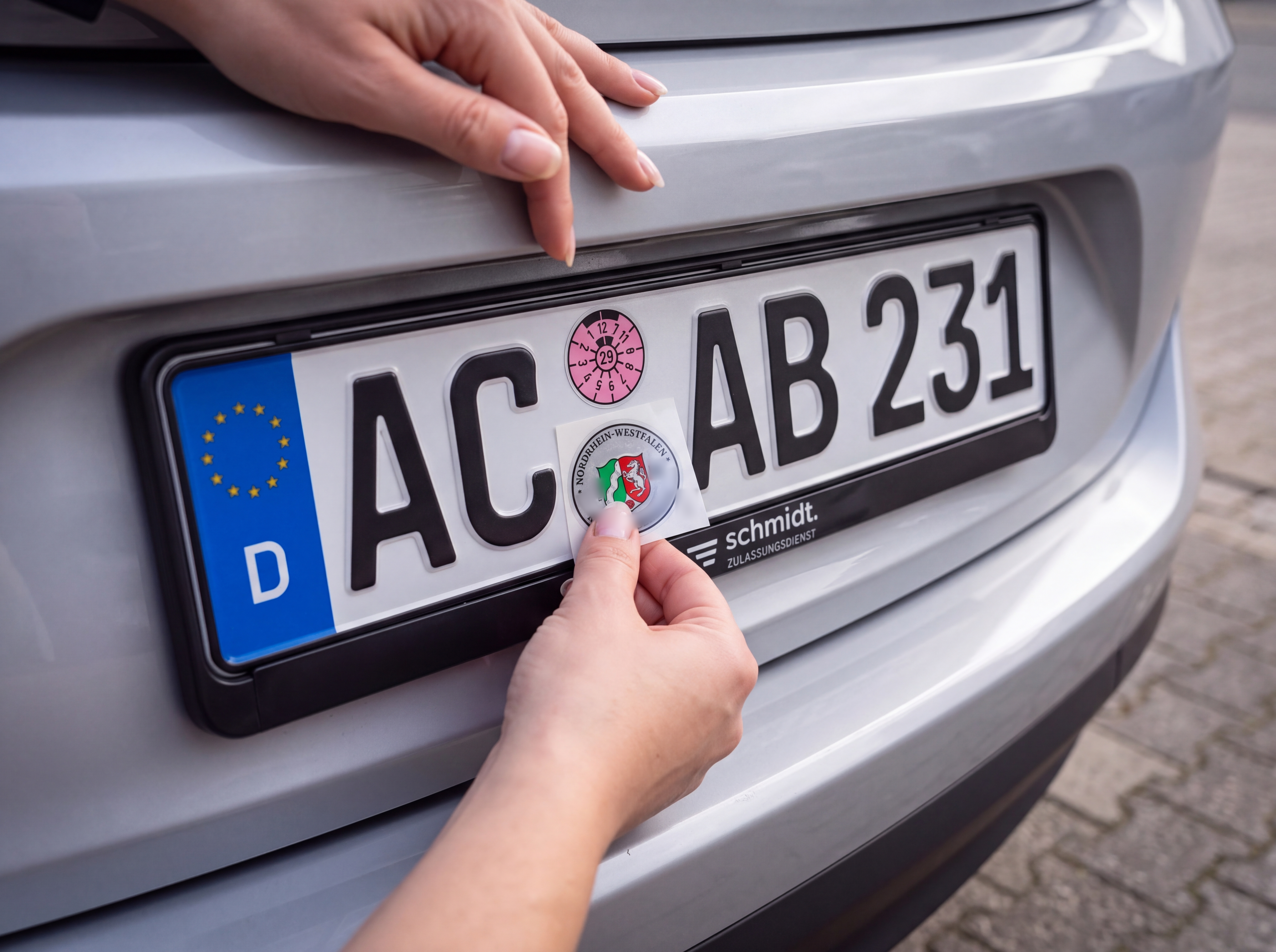Stempelplakette wird auf das Kennzeichen aufgebracht